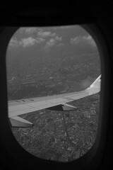 Black and white photo of a plane above the cloud