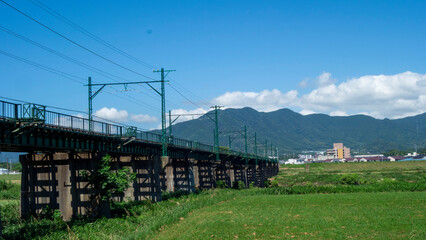 遠賀川に架かる鉄橋と福智山系の真夏の風景