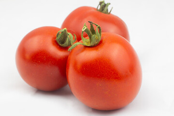 Red tomatoes with green pedicel - three ripe fruits