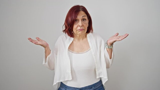 Middle age woman standing clueless over isolated white background