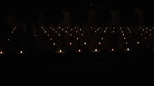 Nighttime graveyard, burning graves, ghostly lamps. Cemetery at night, filled with multitude of lamps, where fire fiercely burns.