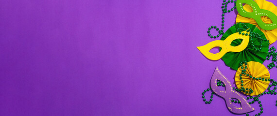 Festive Mardi Gras masquerade purple background. Fat Tuesday carnival, masks, beads, traditional decor