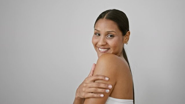 Young latin woman smiling confident touching arm over isolated white background