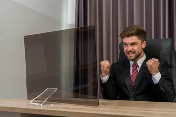 Successful businessman smiles while looking at monitor