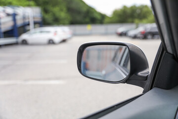 Car mirror reflects life's journeys, offering introspection and foresight. Symbolizes reflection, self-awareness and moving forward