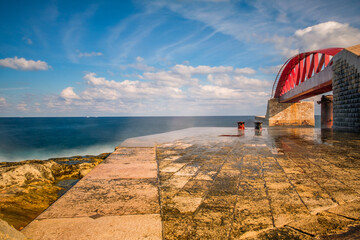 The surf splashes against the St Elmo Breakwater and the spray whips up to the St Elmo Bridge