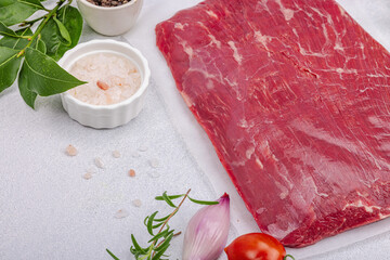 Dry aged Bavette steak with traditional spices and herbs. Fresh raw meat cut, light stone background