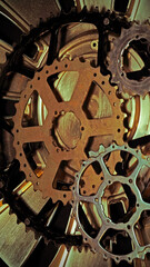 Cog wheels of bicycles and  part of a wheel cover on a black background. Steampunk background. Bicycle. Technical. Mechanical parts. Gears. Cogwheels