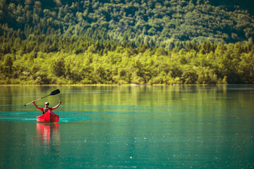 Happy Traveler Inside Red Canoe on a Glacial Lake