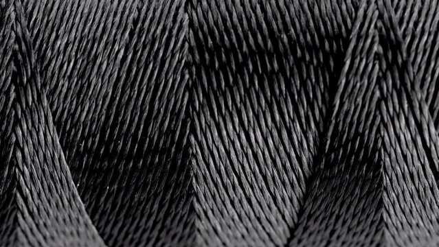 Texture of threads in a spool of black color.