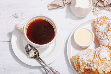 Good morning concept. Breakfast with cup of coffee and fresh croissant. Sweet creamy sauce