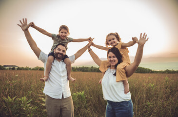 Fototapeta premium Happy family mother father and children daughter on nature sunset