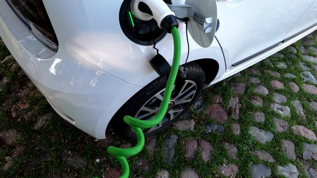 Progressive concept of EV car and home charging station powered by sustainable and clean energy with zero CO2 emission for green environmental. Charging point at residential area for electric vehicle.