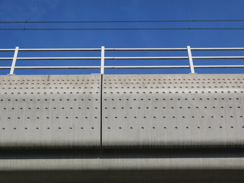 concrete railroadbridge with a dot pattern against a blue sky