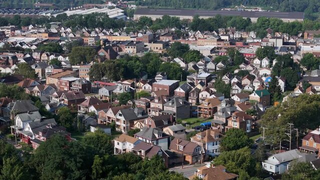 A slowly rotating aerial parallax morning view of the downtown area residential of Ambridge, Pennsylvania, a small suburb of Pittsburgh. Factories along the Ohio River in the distance.  	