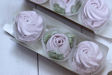 Homemade marshmallows in paper gift boxes. Zephyr flowers. The box is open.