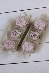Homemade marshmallows in paper gift boxes. Zephyr flowers. The box is open.