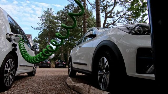 The driver of the electric car inserts the electrical connector to charge the batteries.