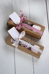 Homemade marshmallows in paper gift boxes. Zephyr flowers. The boxes are tied with a ribbon tied...
