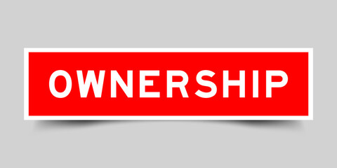 Red color square label sticker with word ownership on gray background