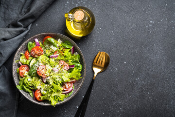 Green vegetable salad with fresh leaves . Top view at black background.