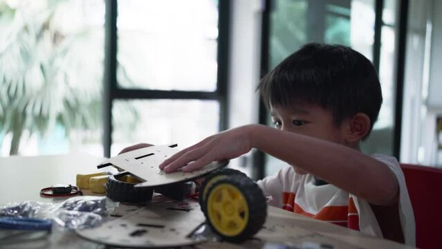 Asian  Student Boy Building Robot Vehicle In After School Computer Coding Class technology of robotics programing and STEM education concept.