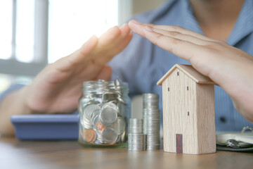 Hand choose prevent house with coins stack in graph shape and piggy bank for real estate or money...
