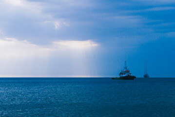 coast guard boat and yacht on the sea in a cloudy evening