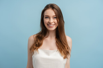 Obraz premium Close up portrait of beautiful smiling woman with long hair, toothy smile looking at camera