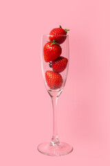 A glass glass full of red ripe strawberries isolated on a pink background. Summer drinks. Summer cocktail. Healthy fruit drinks