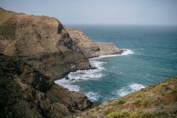 Mesmerizing view of foamy waves splashing on huge cliffs, La Gomera, Spain, Canary Islands