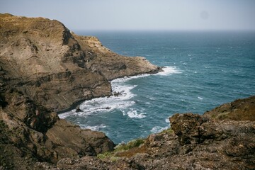 Aerial view of a dramatic rocky cliff overlooking the vast expanse of the ocean