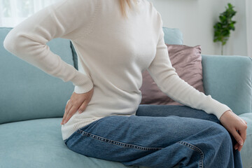 woman holding her lower back while and suffer from unbearable pain health and problems, chronic back pain, backache in office syndrome, scoliosis, herniated disc, muscle inflammation