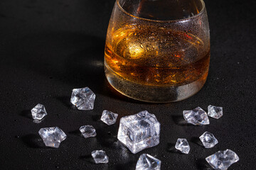 whiskey with ice on a wooden table. Reasonable consumption of alcoholic beverages