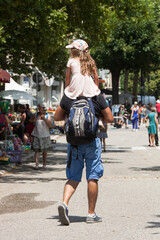 Papa portant sa fillette sur ses épaules lors d'une brocante