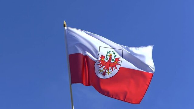The Tyrol flag waving in the wind in the blue sky