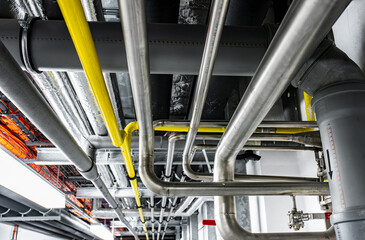 Gas and waste pipelines in the underground premises of the factory, industrial background, building...