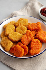 Homemade Spicy Chicken Nuggets Mix with Ketchup on a gray background, side view. Close-up.