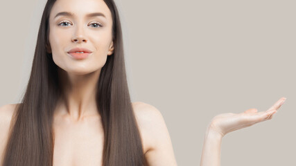 Beautiful young young white shawl with long straight shiny hair shows your products in palm of her hand