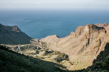 Aerial view of a beautiful coastline situated in an open valley area surrounded by rocky hills