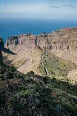 Aerial view of a mountain range with a stunning view of the ocean in the distance