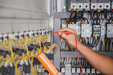 Electrical engineer tests the operation of the electric control cabinet on a regular basis for...
