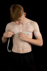 Teenage boy measuring his chest
