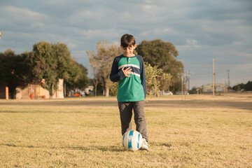 Niño feliz jugando al futbol al aire libre © Leonardo