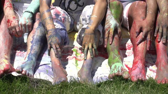 Slow-motion footage of legs of people colored with different paints