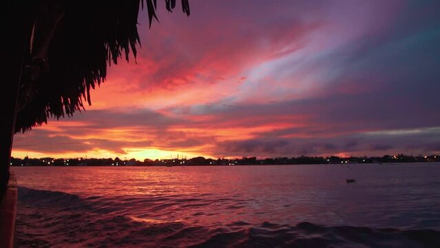 Slow-motion view from a boat driving on a tranquil lake during a vibrant sunset
