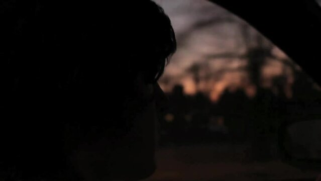 Young Caucasian man driving in the car during sunset