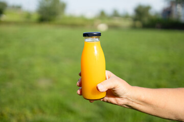 Detox diet vegetable juice concept. Attractive woman holding glass of bottle with fresh pressed...