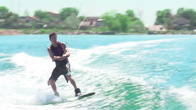 Slow motion of a Caucasian young man wakeboarding and doing tricks