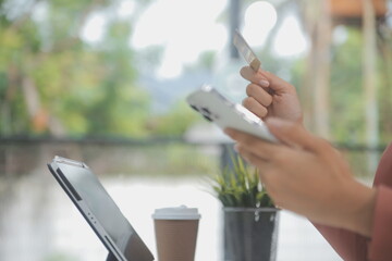 .Women holding credit card and using smartphones at home.Online shopping, internet banking, store...